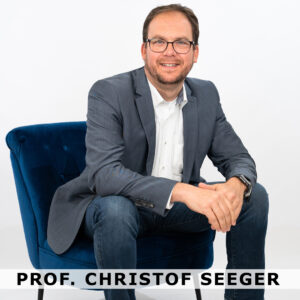 Prof. Christof Seeger auf einem Stuhl sitzend