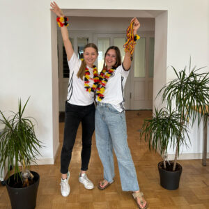 Zwei Frauen in Deutschland Trikots mit Fußball Fanartikeln.