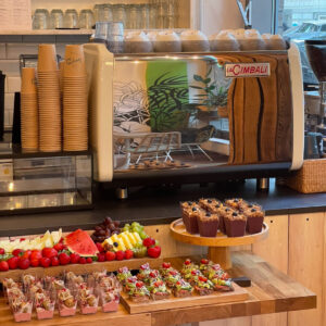 Tisch mit Kaffeemaschine und schön angerichteten Speisen für das Frühstück.